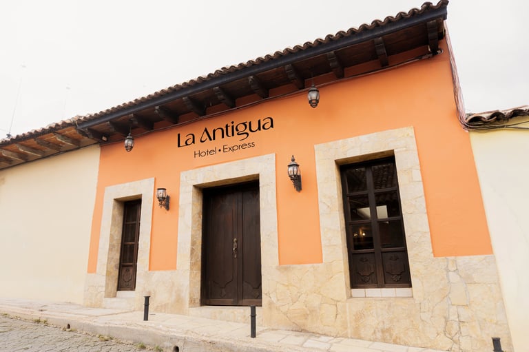 Colonial building with orange and white facade labeled La Antigua
